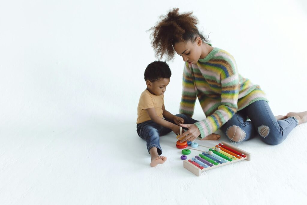 A mother and child playing with colorful educational toys in a bright indoor setting.