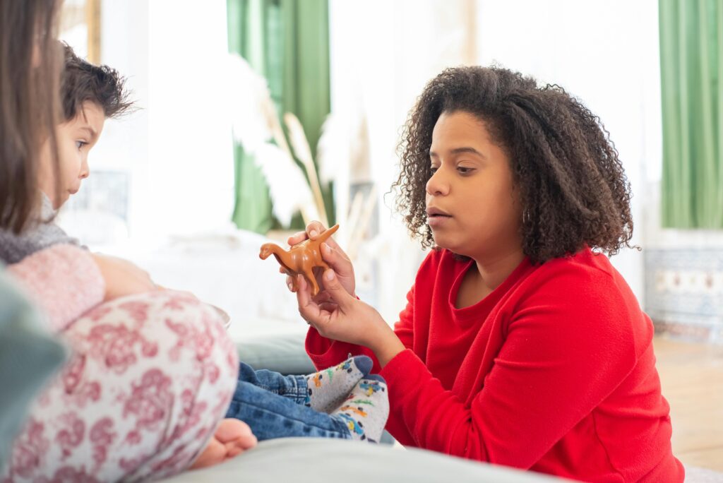 How Parents May Unintentionally Slow Down Therapy Progress (Insights from SensoryCare Therapy Services) A mother and child enjoying playtime with toys in a cozy living room setting.
