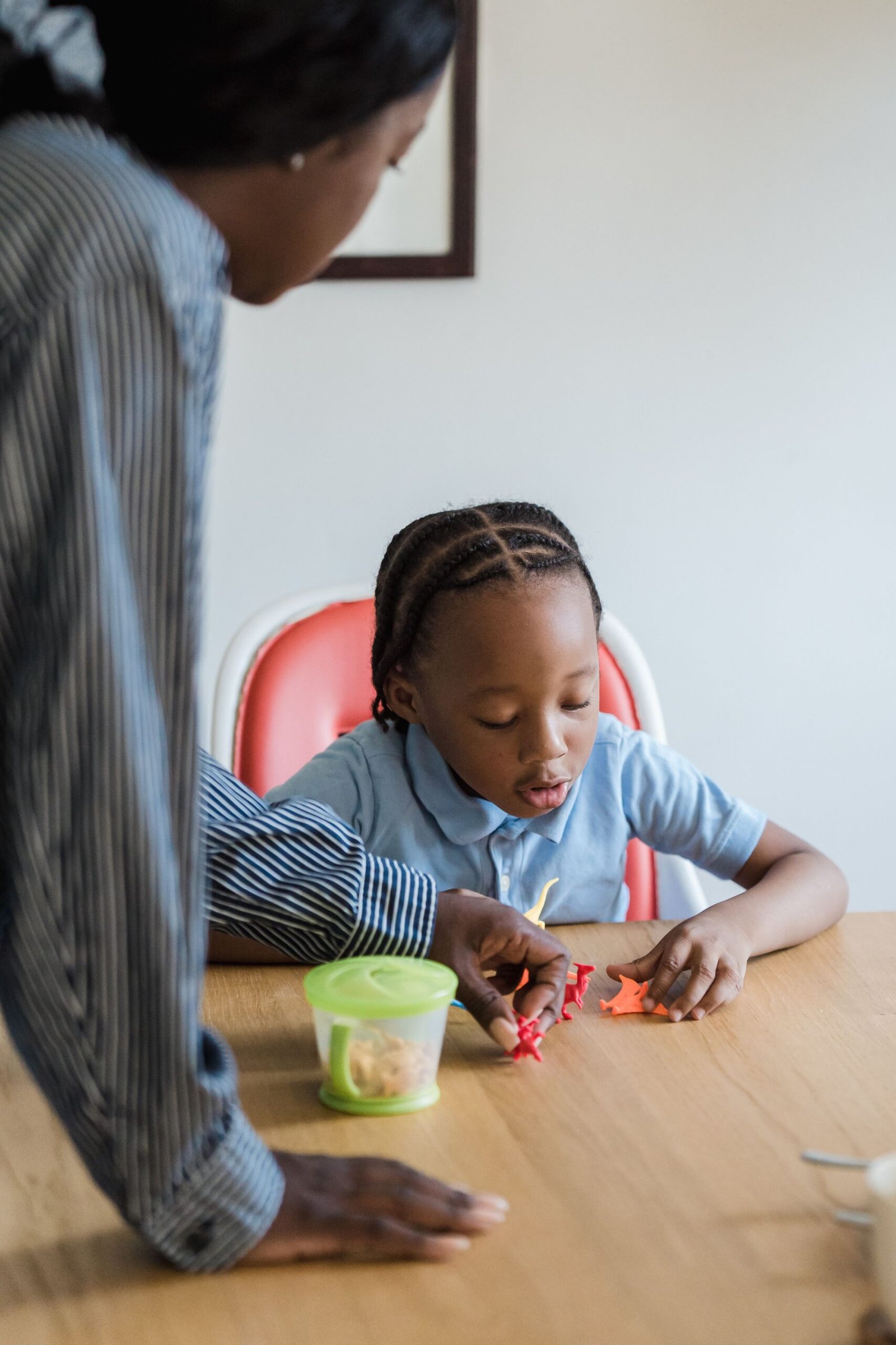 UNDERSTANDING SENSORY PROCESSING DIFFICULTIES A mother and daughter enjoying playtime with toys at a table indoors.