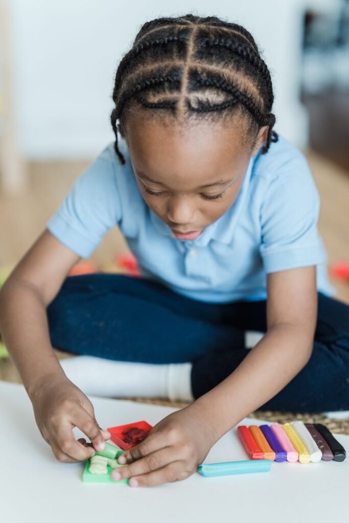 Young child playing with colorful clay indoors, fostering creativity and fun.