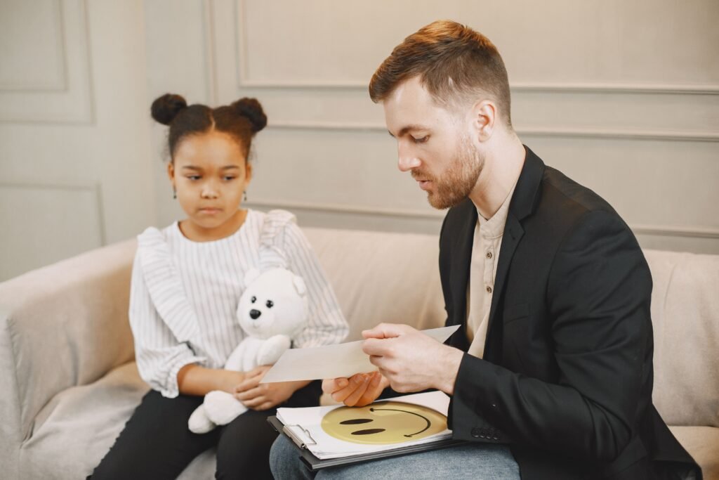 What Is Sensory Integration Therapy? A Simple Guide for Parents A child holding a plush toy listens to a man in a therapy session.